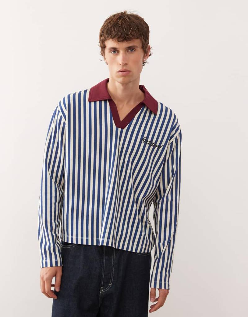 Reclaimed Vintage - Fußball-Polohemd in Blau und Weiß gestreift mit Marken-Grafik Reclaimed Vintage - Fußball-Polohemd in Blau und Weiß gestreift mit Marken-Grafik von Reclaimed Vintage