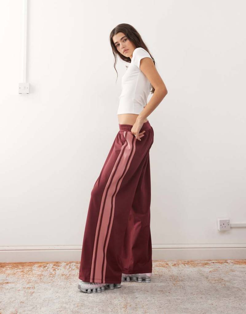 Reclaimed Vintage - Weit geschnittene Schlupf-Jogginghose in Burgunderrot und Rosa mit farblich abgesetzter Bahn von Reclaimed Vintage