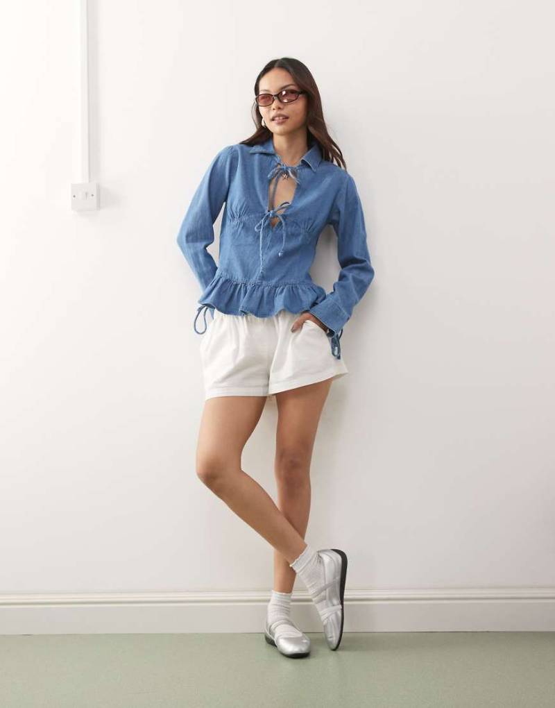 Reclaimed Vintage - Langärmliges Jeans-Oberteil in Mittelblau mit gebundener Vorderseite und Schößchensaum von Reclaimed Vintage