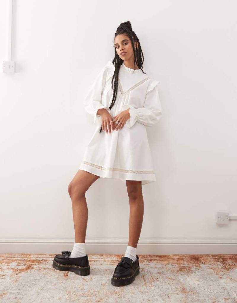 Reclaimed Vintage - Mini-Hängerkleid in Weiß mit eingesetzten Spitzenbesätzen und Rüschen von Reclaimed Vintage