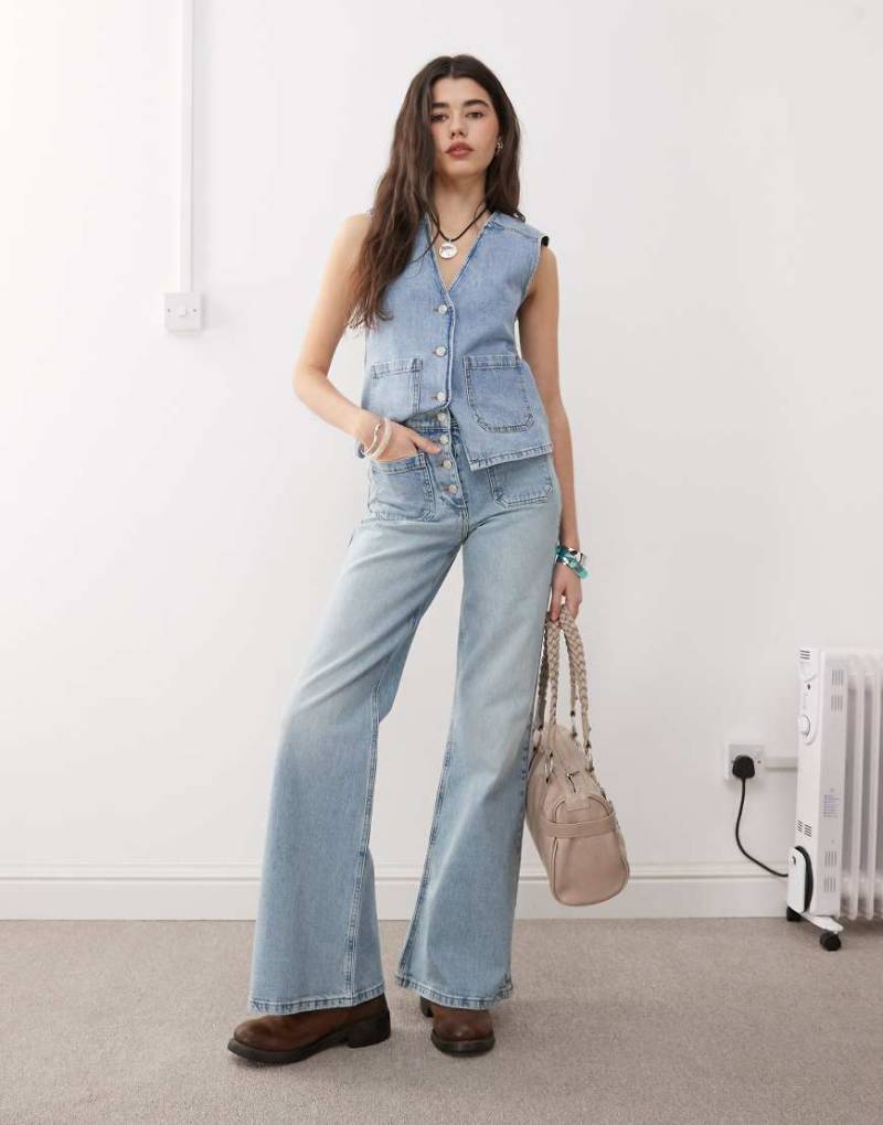 Reclaimed Vintage - Palazzo-Jeans im Stil der 70er mit aufgesetzten Taschen und Knopfverschluss in blauer Waschung von Reclaimed Vintage