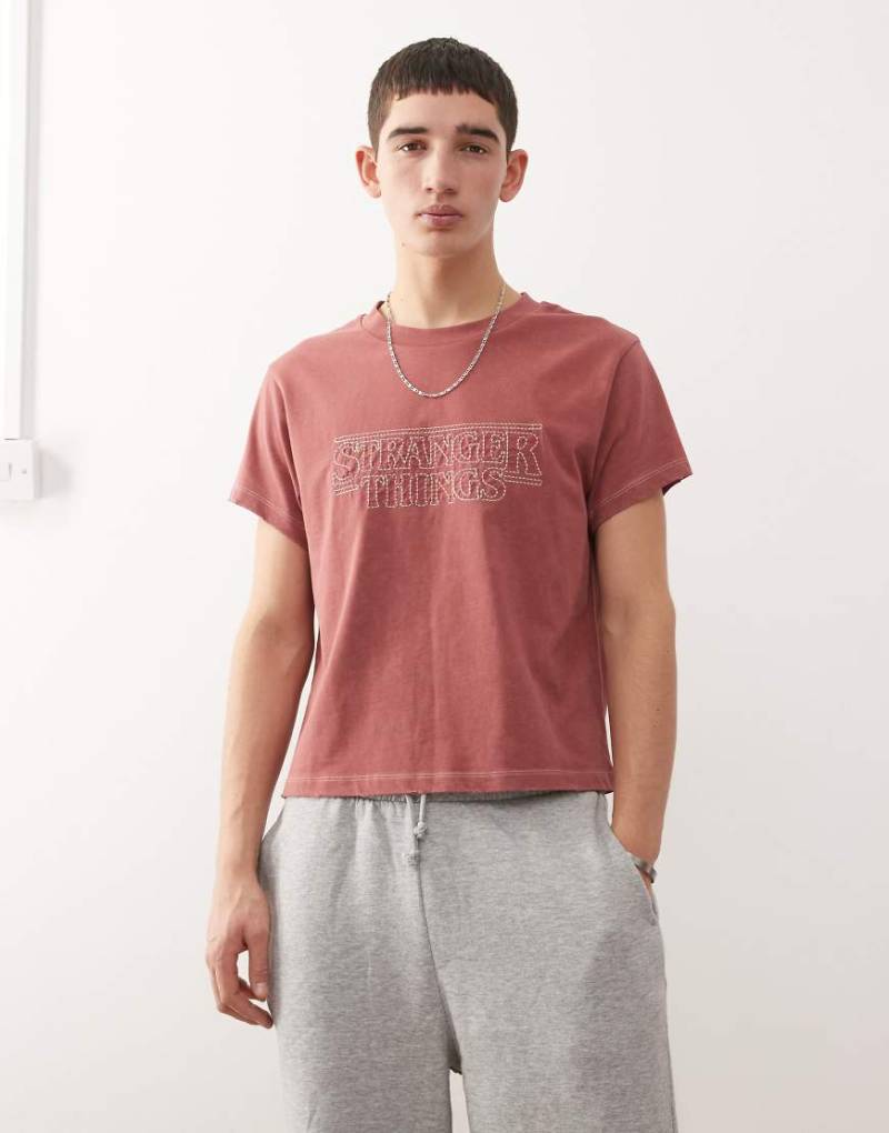 Reclaimed Vintage x Stranger Things - Boxy-Fit-T-Shirt in verwaschenem Rot mit aufgesticktem Logo-Bunt von Reclaimed Vintage