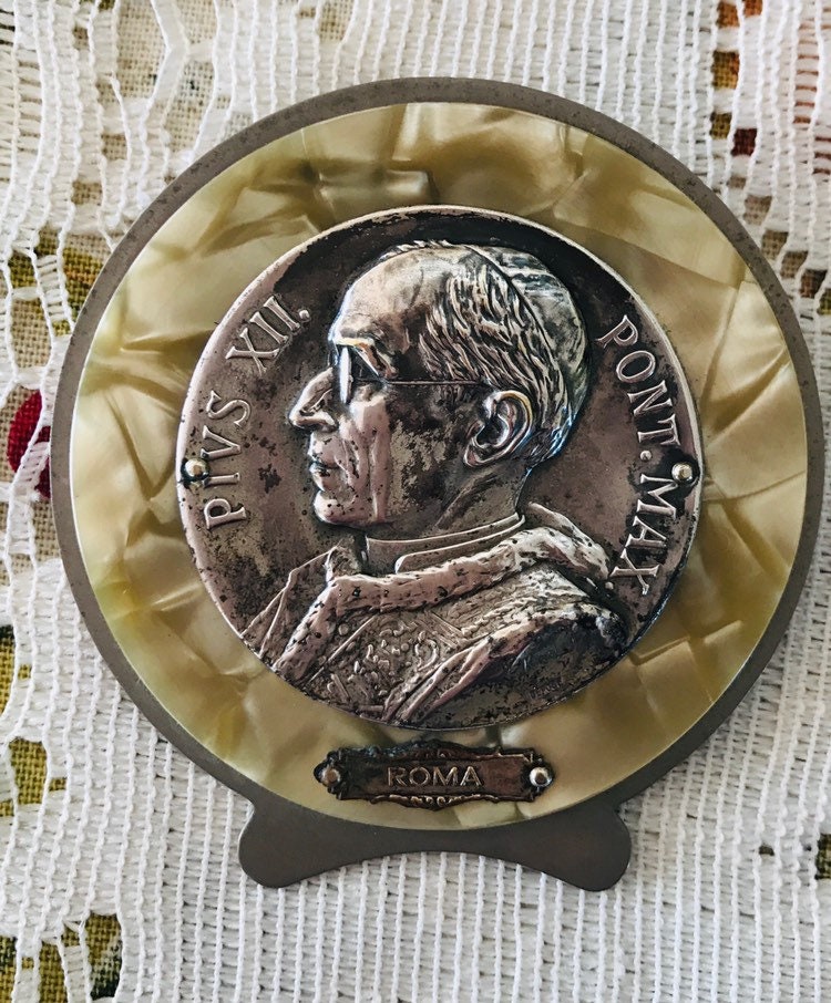 Vintage Pope Pius Xll Versilbertes Medaillon Staffelei Auf Perlmuttfarbenem Hintergrund Vintage Pope Pius Xll Versilbertes Medaillon Staffelei Auf Perlmuttfarbenem Hintergrund von RememberWhenByMaryB
