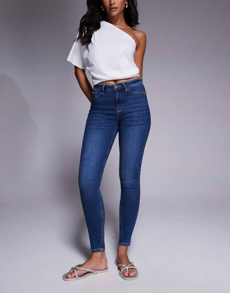 River Island - Figurformende Skinny-Jeans in verwaschenem Dunkelblau mit mittelhohem Bund von River Island