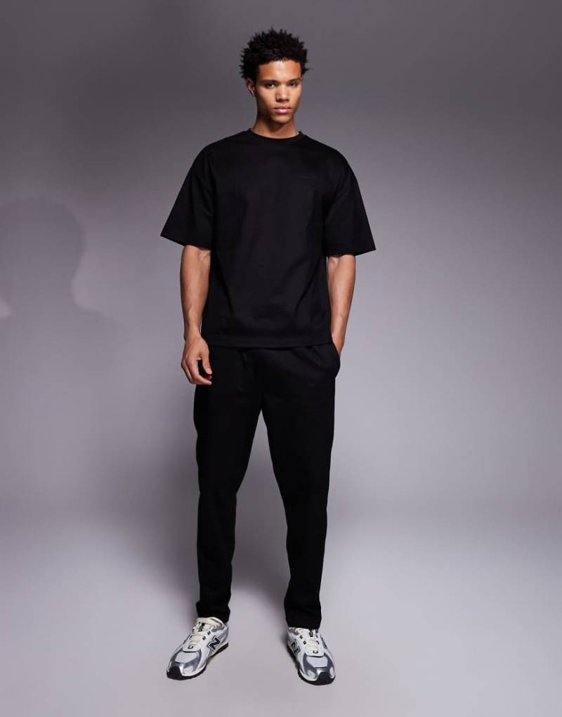 River Island - Jersey-Set in Schwarz, bestehend aus Jogginghose und T-Shirt von River Island
