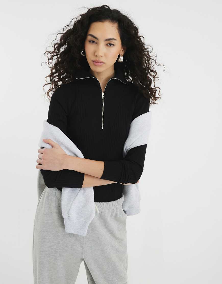 River Island - Langärmliges, geripptes Oberteil in Schwarz mit Reißverschluss vorne River Island - Langärmliges, geripptes Oberteil in Schwarz mit Reißverschluss vorne von River Island
