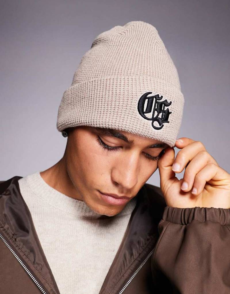 River Island - Waffelstrick-Mütze in hellem Stein mit Logodetail-Neutral von River Island