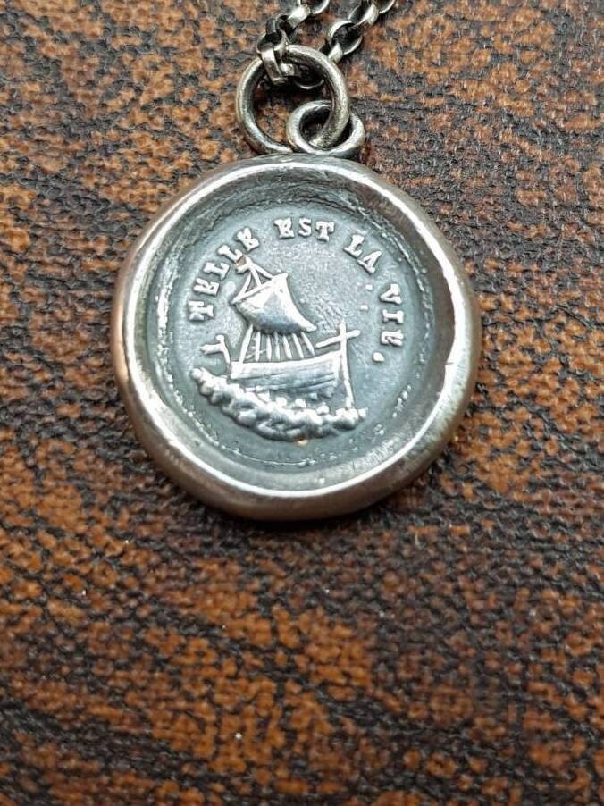 Telle Est La Vie, Wie Rettungsboot Anhänger. Antikes Wachs Buchstaben Siegel. Rauhe See, Unwetternde Stürme Telle Est La Vie, Wie Rettungsboot Anhänger. Antikes Wachs Buchstaben Siegel. Rauhe See, Unwetternde Stürme von SWALKDESIGNS