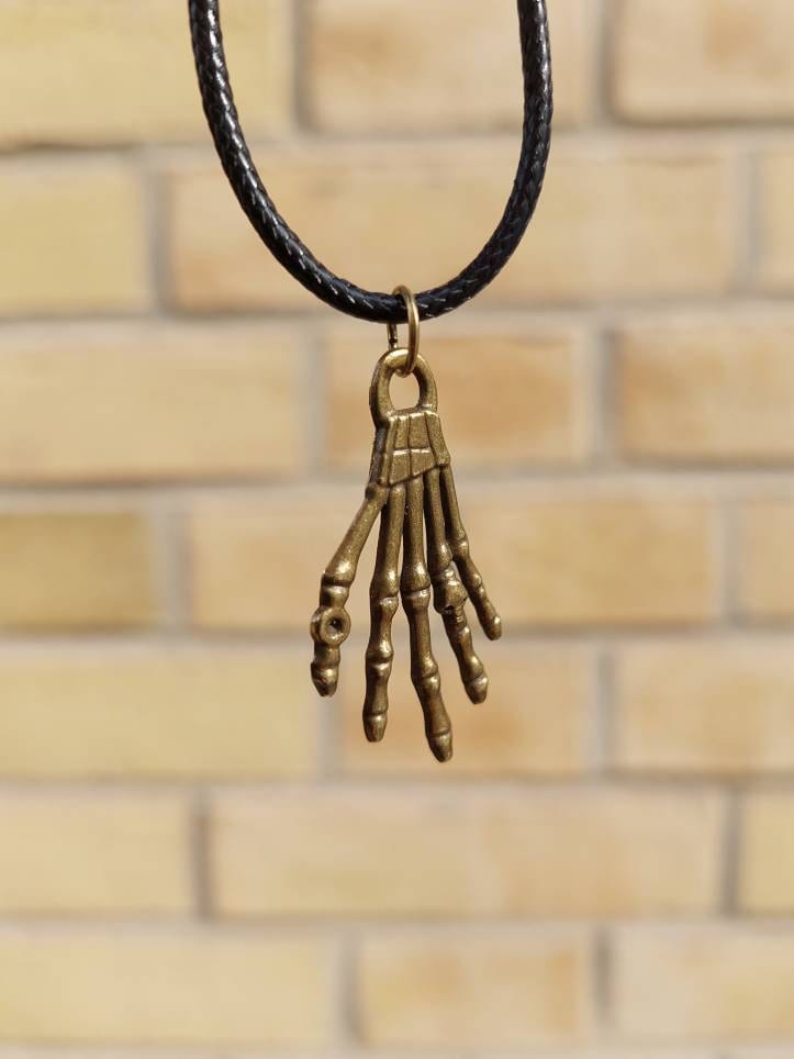 Schwarze Kette Mit Kleiner Bronzefarbener Skeletthand Als Anhänger von SchniekeDesign