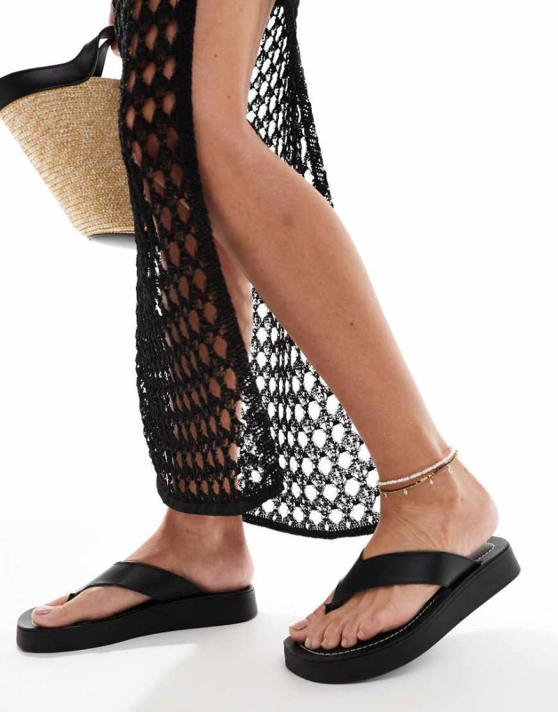 schuh - Tanisha - Flache Zehensteg-Sandalen aus schwarzem Leder mit flacher Plateausohle von Schuh