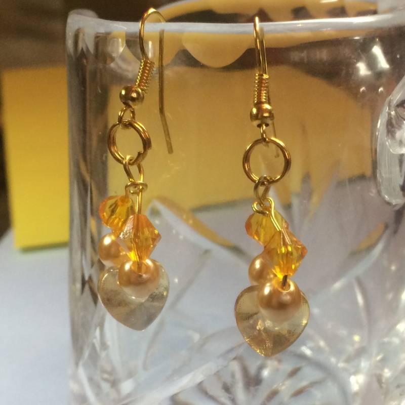 Goldene Hängeohrringe Mit Precioso-Herzen, Hellgelben Perlen Und Bicones Goldene Hängeohrringe Mit Precioso-Herzen, Hellgelben Perlen Und Bicones von SeaGemJewellery