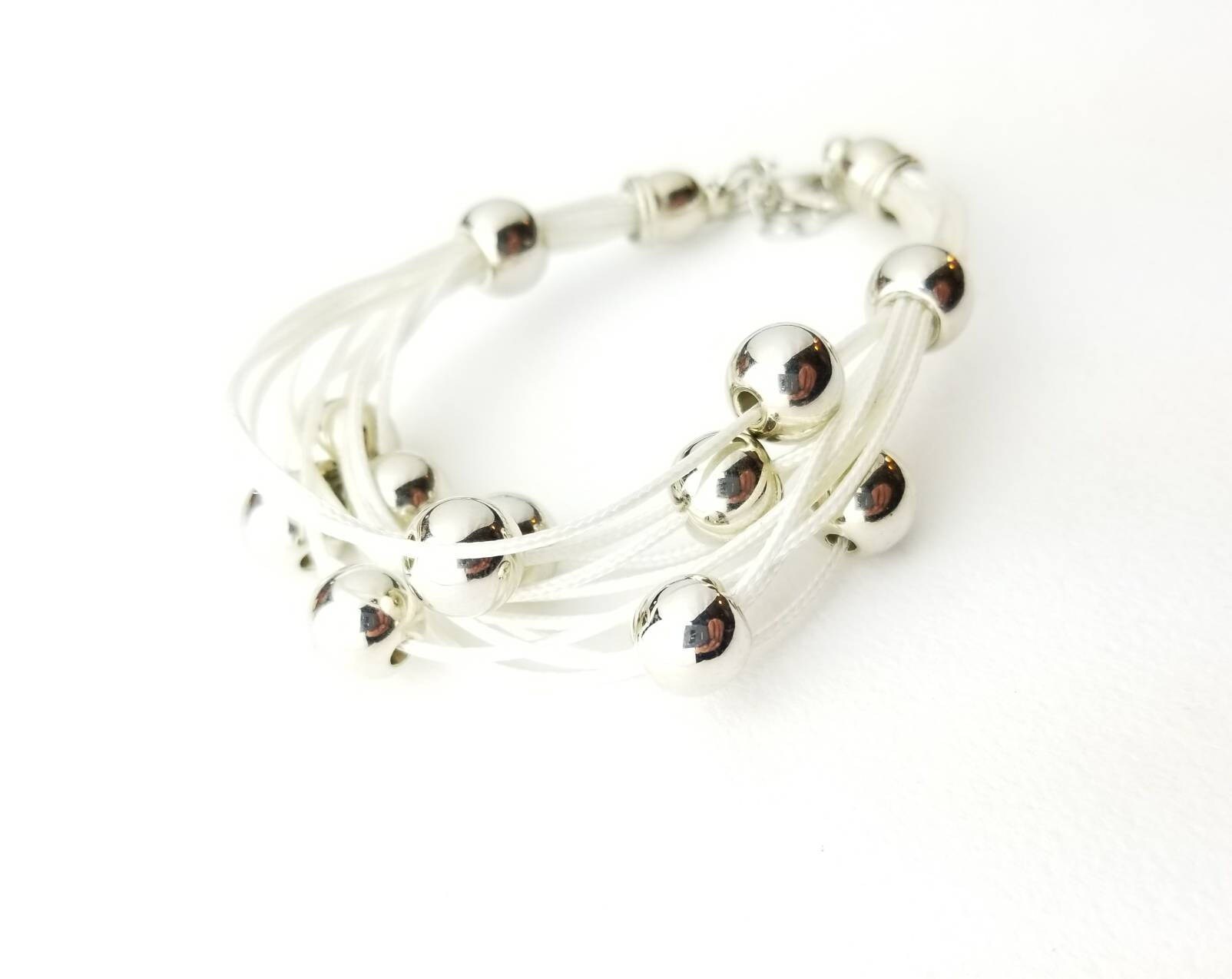 Retro Vintage Weißes Cord Multistrand Armband Mit Mehreren Glänzenden Runden Perlen Retro Vintage Weißes Cord Multistrand Armband Mit Mehreren Glänzenden Runden Perlen von SilverAppleGalleries