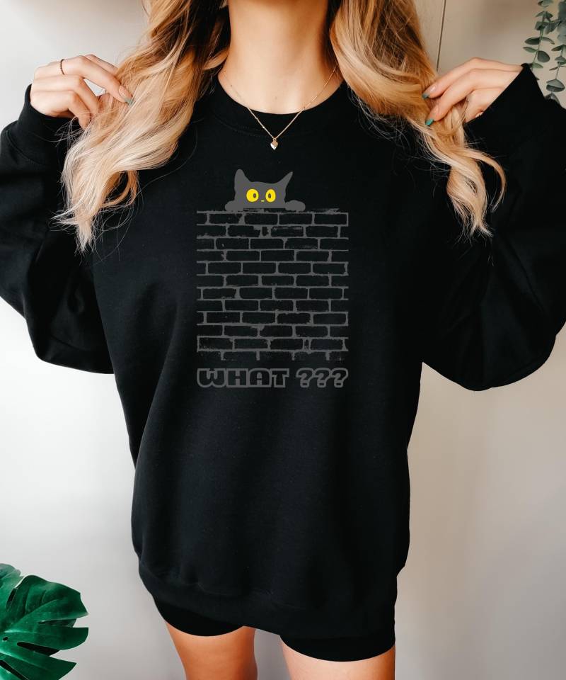 Sweat Shirt What? Mit Katze Die Über Eine Mauer Schaut. Farbe Schwarz, Witzig, What??, Partysweatshirt, Freizeitsweatshirt, Graue Schrift von Soulpixel4you