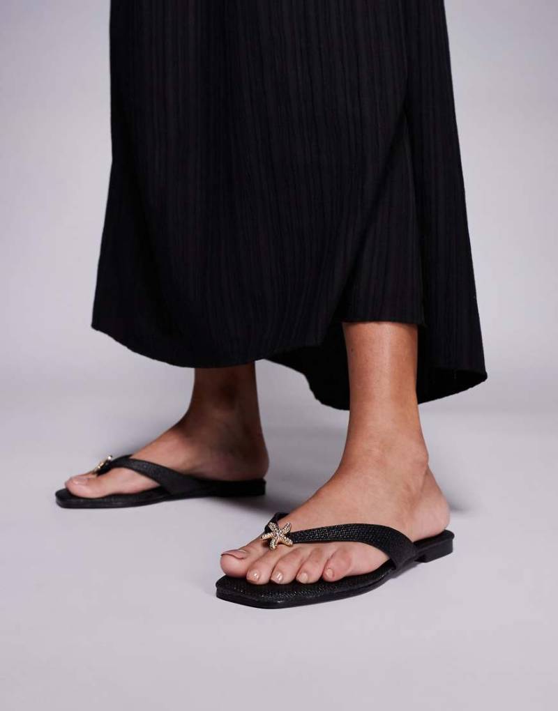 South Beach - Zehenstegsandalen aus Bast in Schwarz mit Seestern-Verzierung South Beach - Zehenstegsandalen aus Bast in Schwarz mit Seestern-Verzierung von South Beach