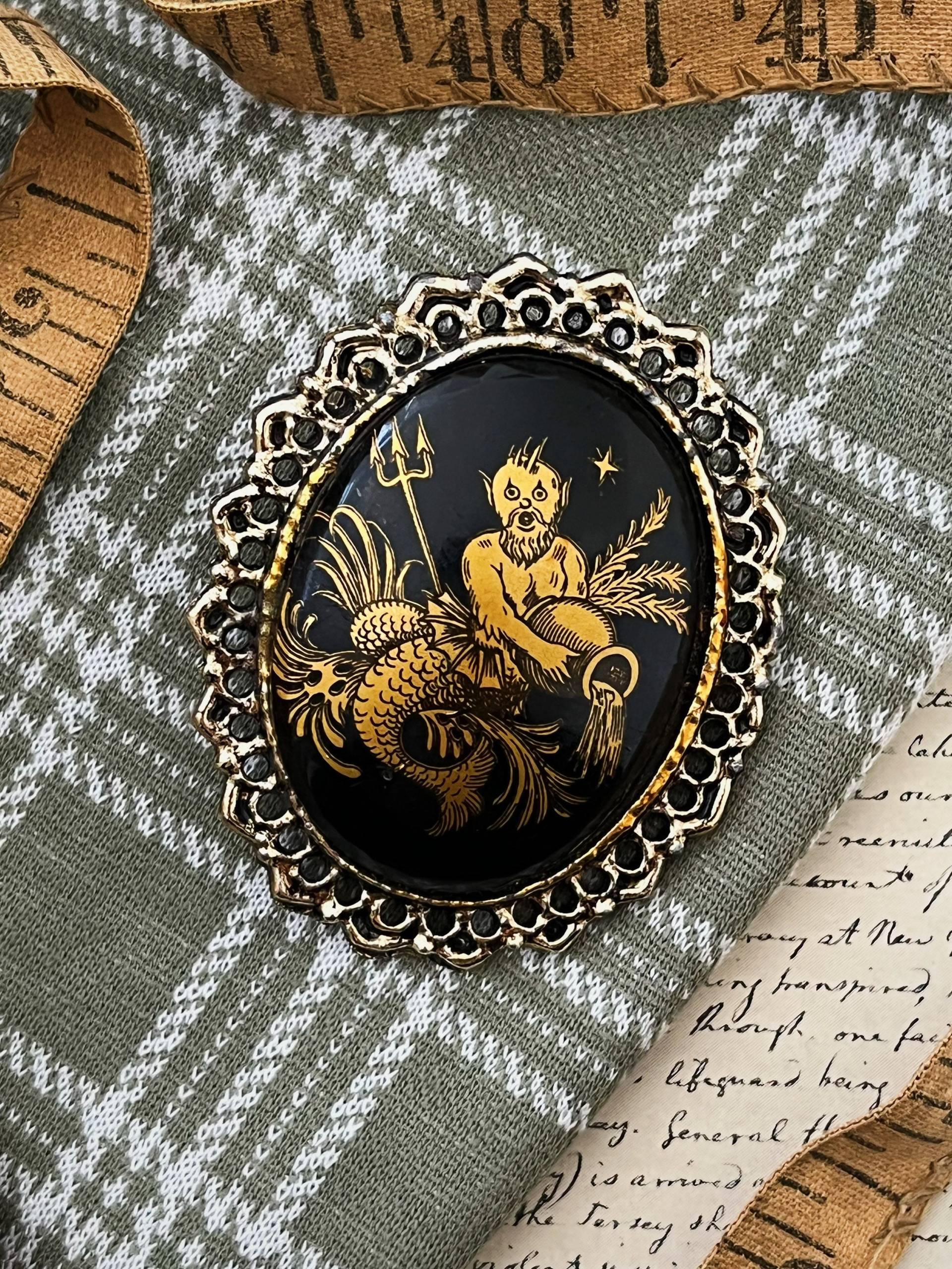 Schwarz Und Gold Midcentury Handbemalter Ovaler Cabochon Mit Neptun Gießwasser Auf Silberfarbener Metallbrosche Schwarz Und Gold Midcentury Handbemalter Ovaler Cabochon Mit Neptun Gießwasser Auf Silberfarbener Metallbrosche von SpottedDeerFinds