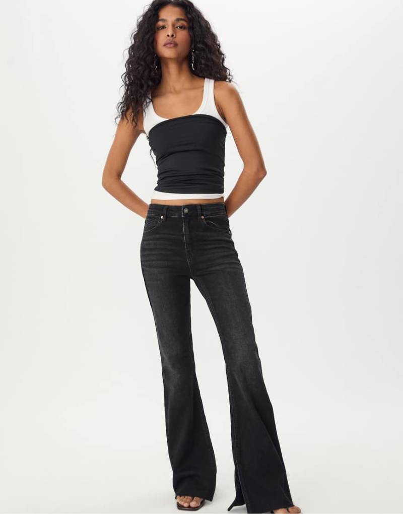 Stradivarius - Ausgestellte Jeans in schwarzer Rinse-Waschung mit Saumschlitz von Stradivarius