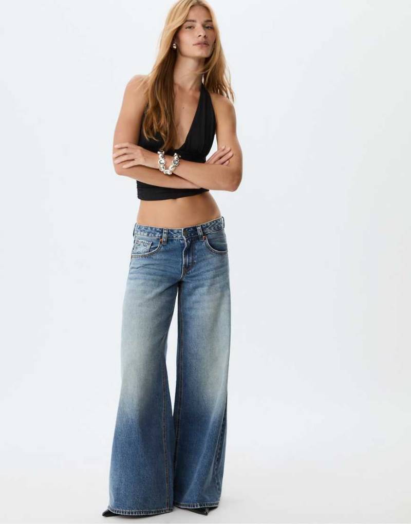 Stradivarius - Jeans aus mittelblauem Denim mit Sternen, weitem Bein und niedrigem Bund von Stradivarius