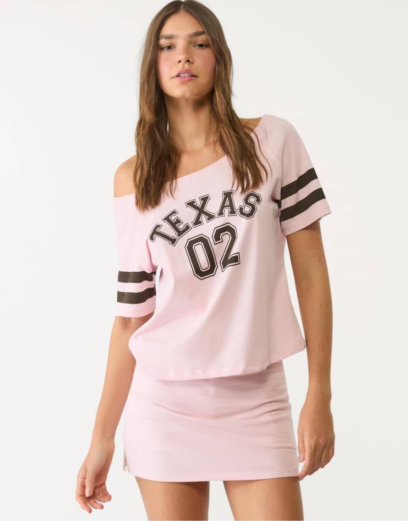 Stradivarius - Kurzärmliges T-Shirt in Pastellrosa mit „Texas"-Grafikprint von Stradivarius