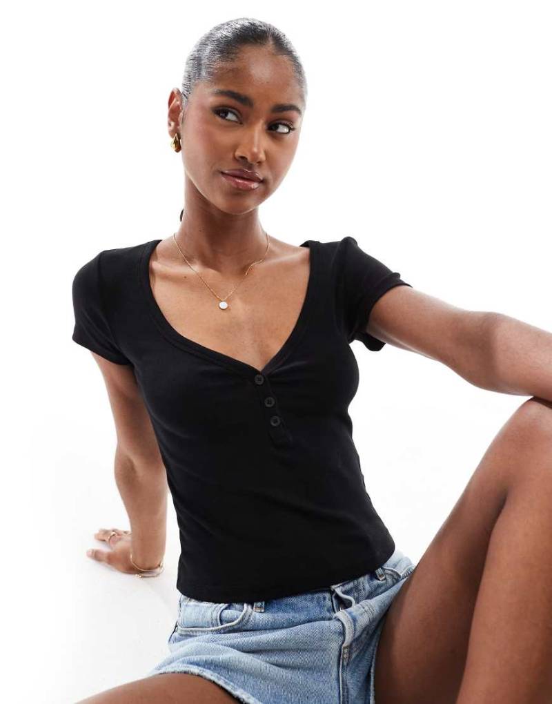 Stradivarius - Kurzärmliges T-Shirt in Schwarz mit Knopfleiste von Stradivarius