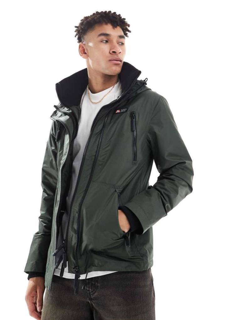 Superdry - Hooded Mountain - Windjacke mit Kapuze in Surplus-Goods-Olivgrün von Superdry