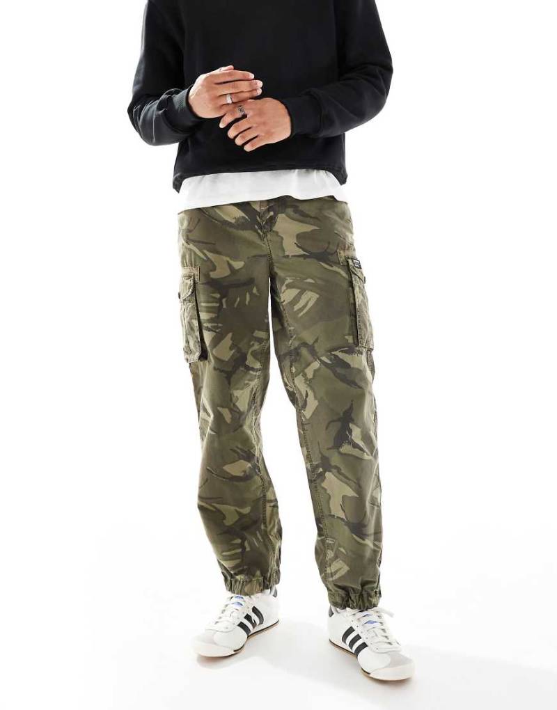 Superdry - Parachute - Leichte Cargo-Shorts in Outline-Military-Muster-Grün von Superdry