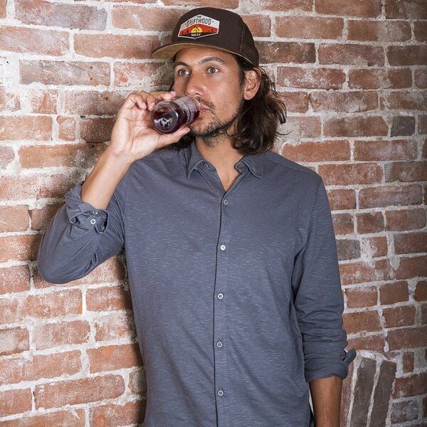 The Driftwood Tales Dunkelbraune Trucker Cap mit orangefarbenem Verstellgurt und Driftwood-Emblem von The Driftwood Tales