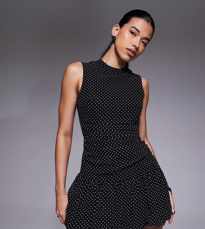 The Frolic - Exclusive - Ärmelloses, hochgeschlossenes Kleid in Schwarz mit Polka Dots und abfallendem Saum mit Falten von The Frolic