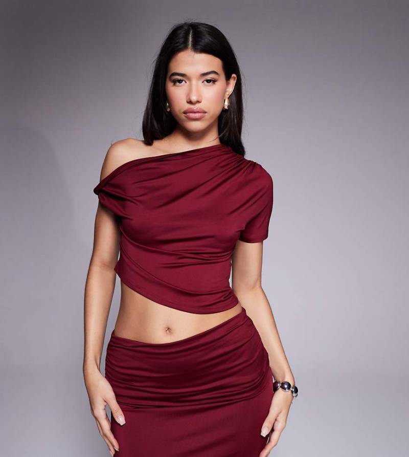 The Frolic - Exclusive - Figurbetontes Cropped-Top in Burgunderrot mit asymmetrischem Schnitt und verdrehtem Off-Shoulder-Träger, Kombiteil von The Frolic