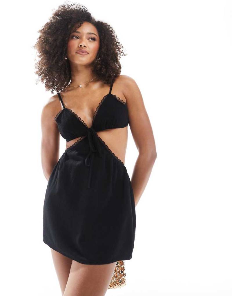 The Frolic Exklusiv - Kurzes Strand-Kleid aus Leinenmix in Schwarz mit V-Ausschnitt, Cut-out-Design und Spitzenbesatz von The Frolic