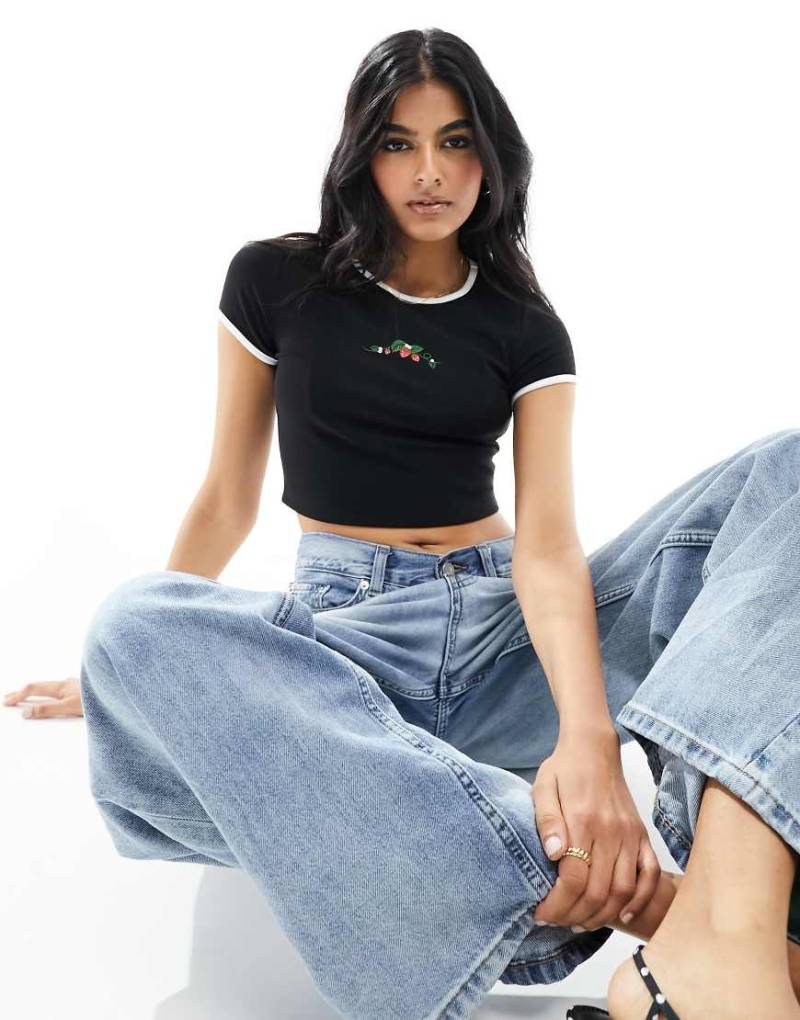 The Frolic - Exklusives, knapp geschnittenes T-Shirt in Schwarz mit Kontrasteinfassungen und Erdbeer-Motiv von The Frolic