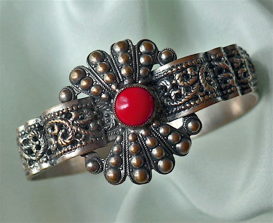 Armband, Boho, Vintage. Gepresstes Metall Mit Floralem Design, Verziert Einem Roten Glascabachon, Getöntes Messing. C1920 Armband, Boho, Vintage. Gepresstes Metall Mit Floralem Design, Verziert Einem Roten Glascabachon, Getöntes Messing. C1920 von TheLadyatSkiers