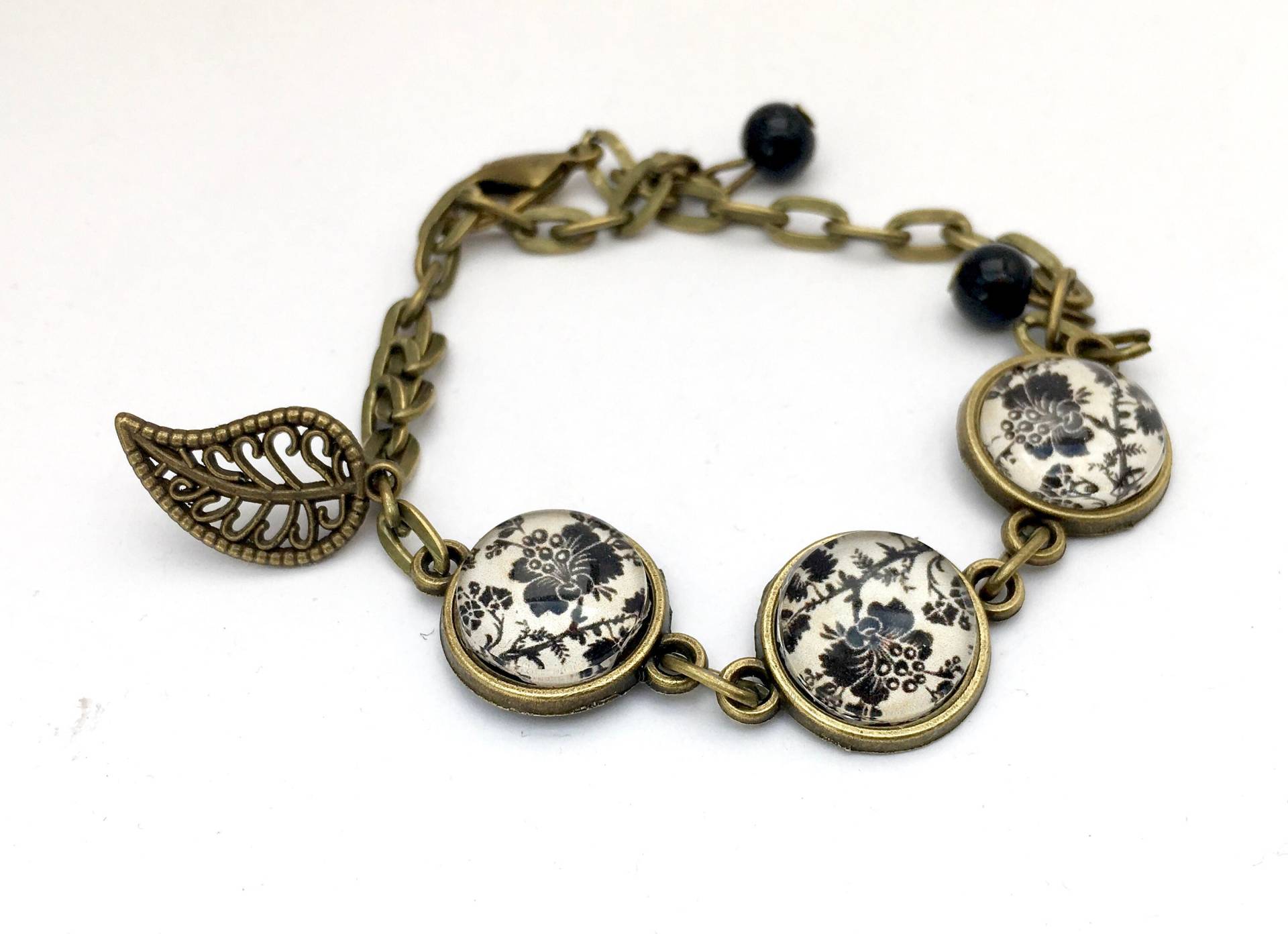 Armband Für Kinder Oder Erwachsene, Schwarze Blumen Auf Beigem Grund, Perlen Und Ein Blattanhänger von Thisliacreations