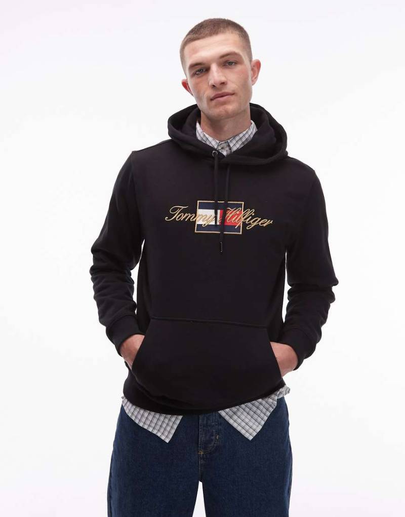 Tommy Hilfiger - Kapuzenpullover in Schwarz mit Flag-Print und goldfarbenem Detail von Tommy Hilfiger