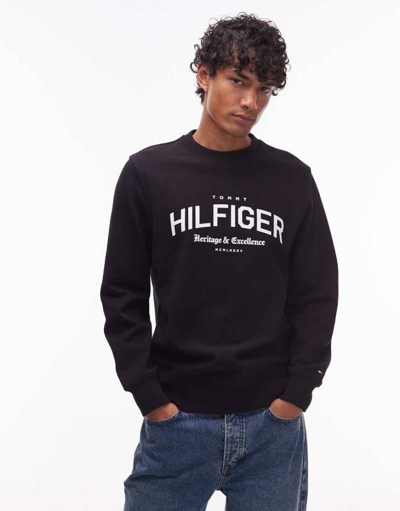 Tommy Hilfiger - Sweatshirt in Schwarz mit großem, gebogenem Logo in der Mitte und Rundhalsausschnitt von Tommy Hilfiger