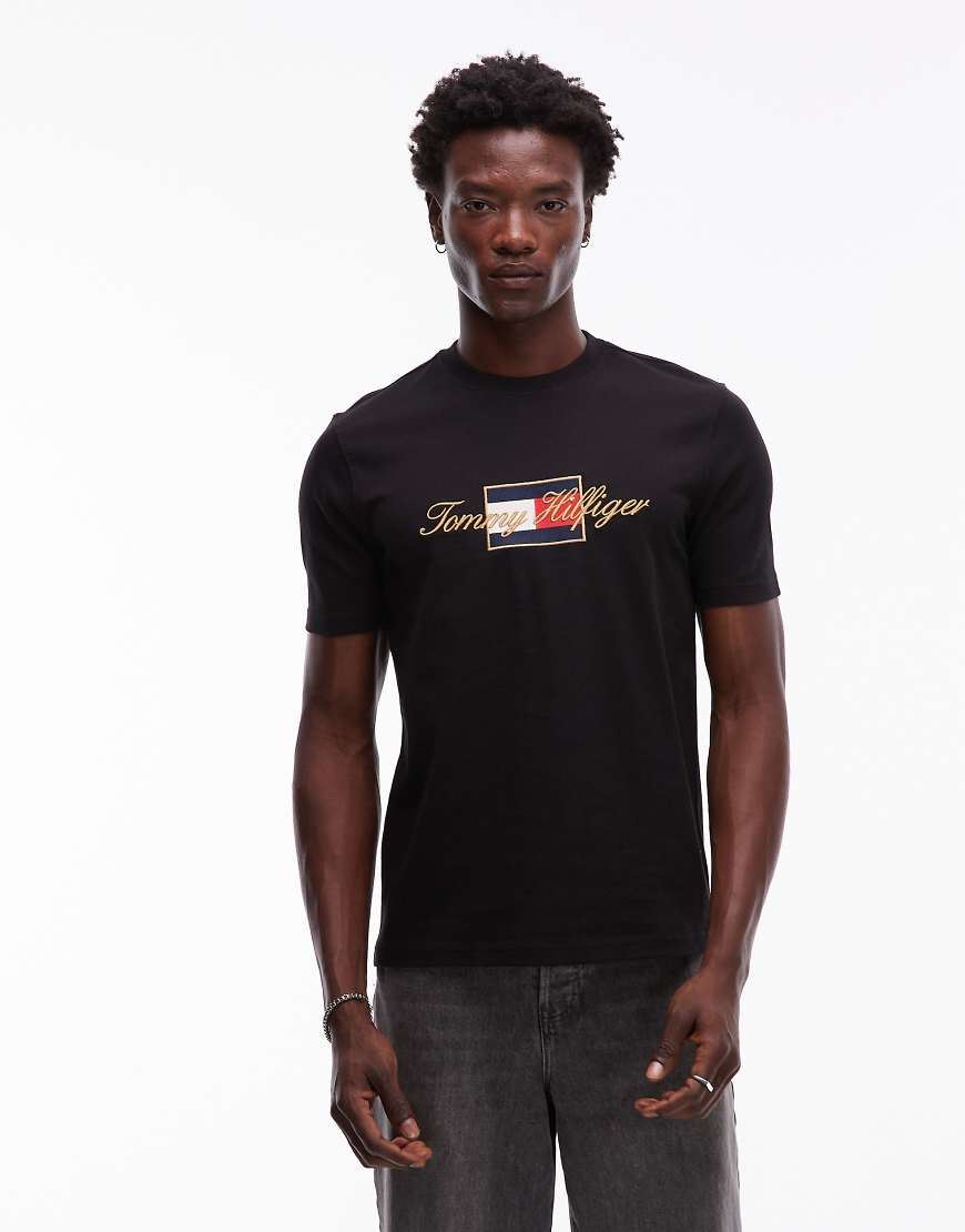 Tommy Hilfiger - T-Shirt in Schwarz mit Flag-Grafik und goldfarbenem Detail von Tommy Hilfiger