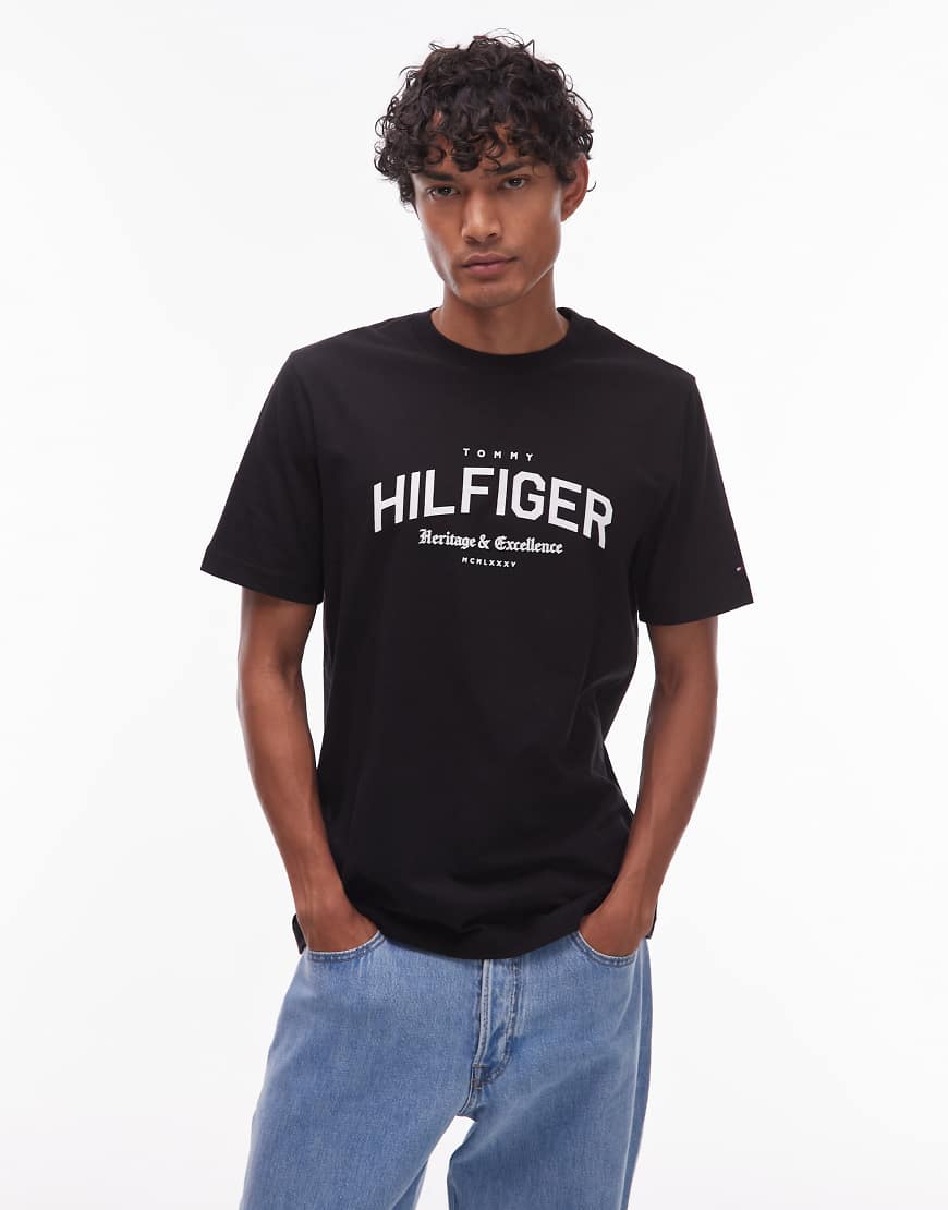 Tommy Hilfiger - T-Shirt in Schwarz mit gebogenem College-Logo von Tommy Hilfiger