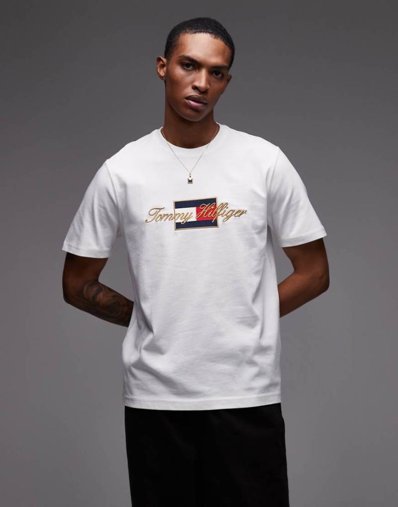 Tommy Hilfiger - T-Shirt in Weiß mit Flag-Grafik und goldfarbenem Detail von Tommy Hilfiger