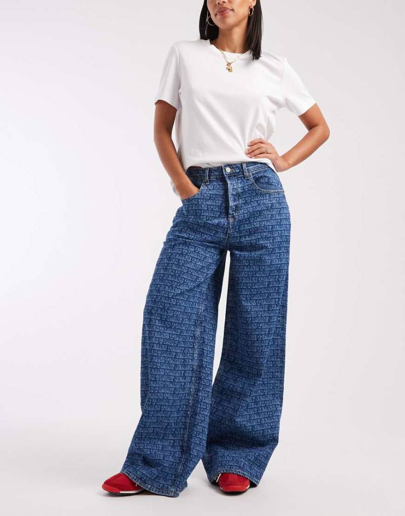 Tommy Jeans - Charlie - Locker geschnittene Jeans in mittlerer Waschung mit All-over-Logoprint-Blau von Tommy Jeans