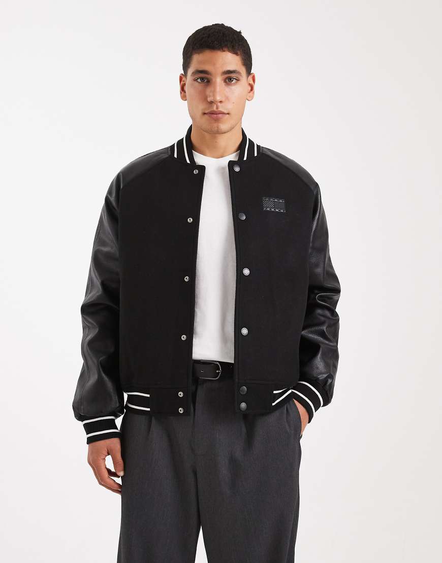 Tommy Jeans - College-Jacke in Schwarz mit Ärmeln aus Leder und Flag-Logo von Tommy Jeans