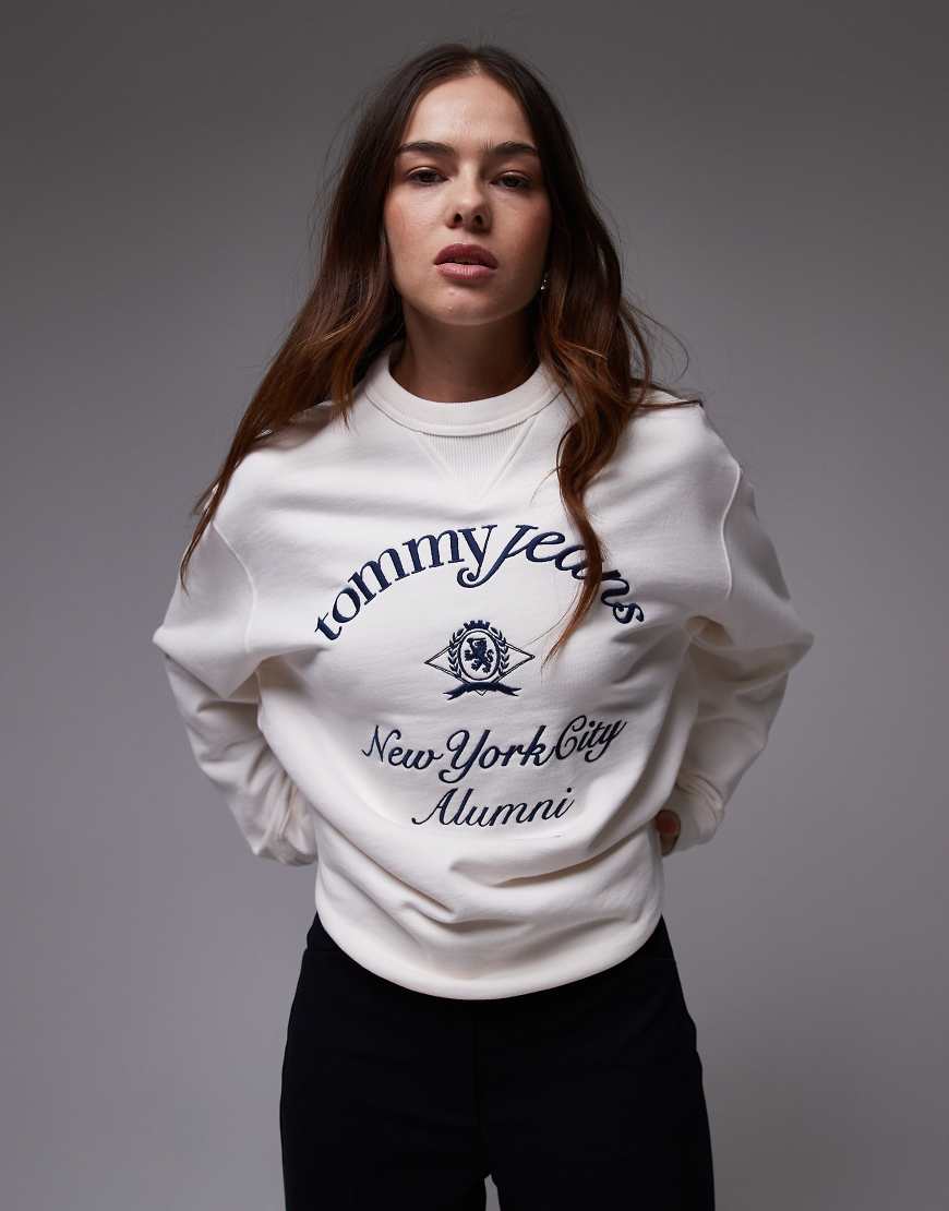 Tommy Jeans - College-Sweatshirt in Weiß mit „New York"-Schriftzug Tommy Jeans - College-Sweatshirt in Weiß mit „New York"-Schriftzug von Tommy Jeans