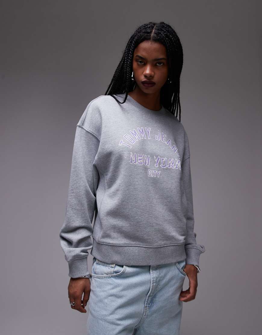 Tommy Jeans - Kastiger Pullover in Grau mit College-Logo und Rundhalsausschnitt Tommy Jeans - Kastiger Pullover in Grau mit College-Logo und Rundhalsausschnitt von Tommy Jeans