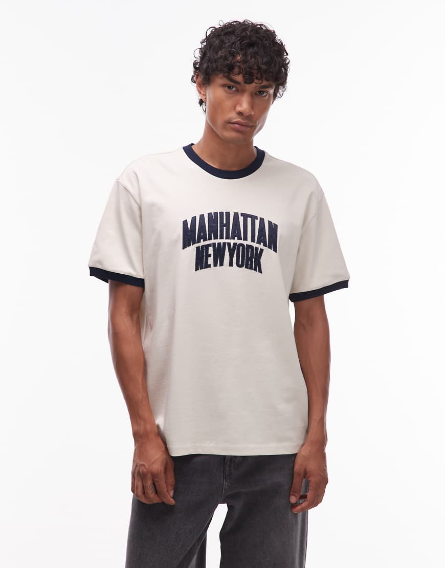 Tommy Jeans - Ringer-T-Shirt in Wollweiß mit Manhattan-Schriftzug Tommy Jeans - Ringer-T-Shirt in Wollweiß mit Manhattan-Schriftzug von Tommy Jeans