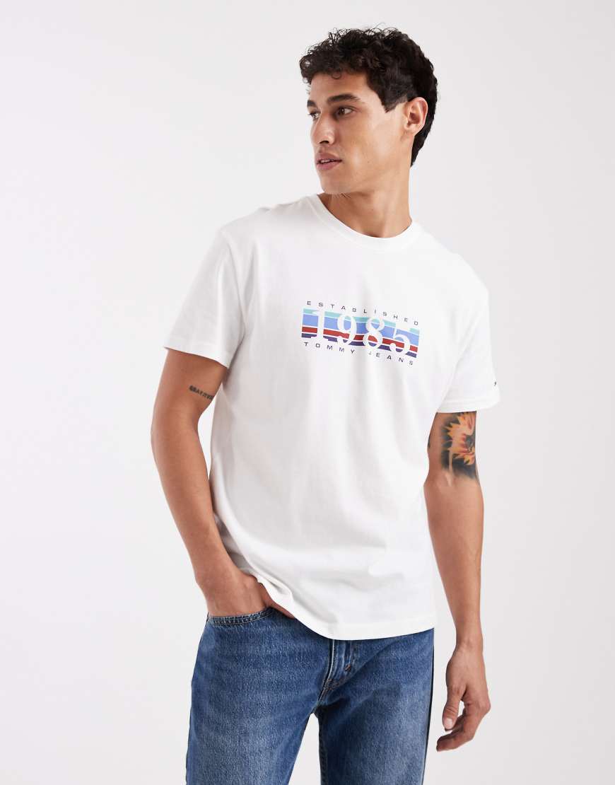 Tommy Jeans - T-Shirt in Weiß mit „1985"-Grafikmotiv und Box-Logo von Tommy Jeans
