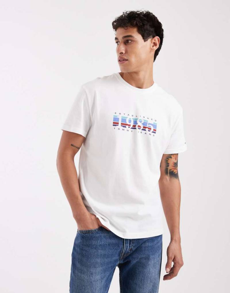 Tommy Jeans - T-Shirt in Weiß mit „1985"-Grafikmotiv und Box-Logo von Tommy Jeans