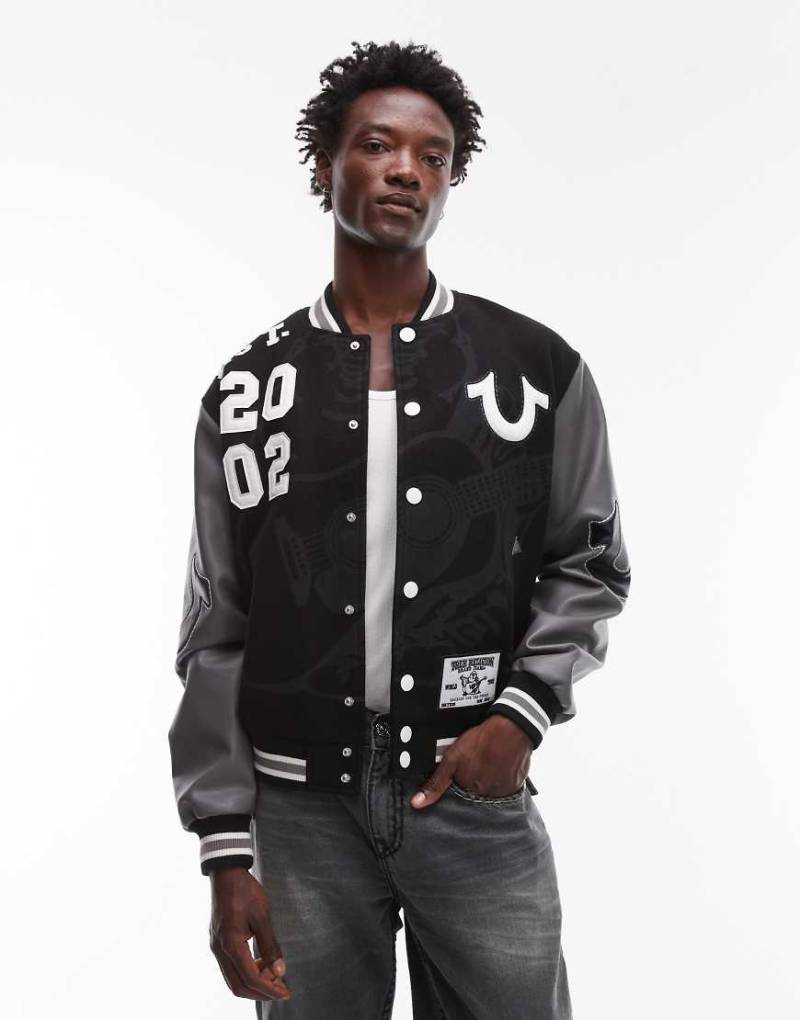 True Religion - College-Bomberjacke in Schwarz mit Aufnäherdetails und Ärmeln aus Kunstleder von True Religion