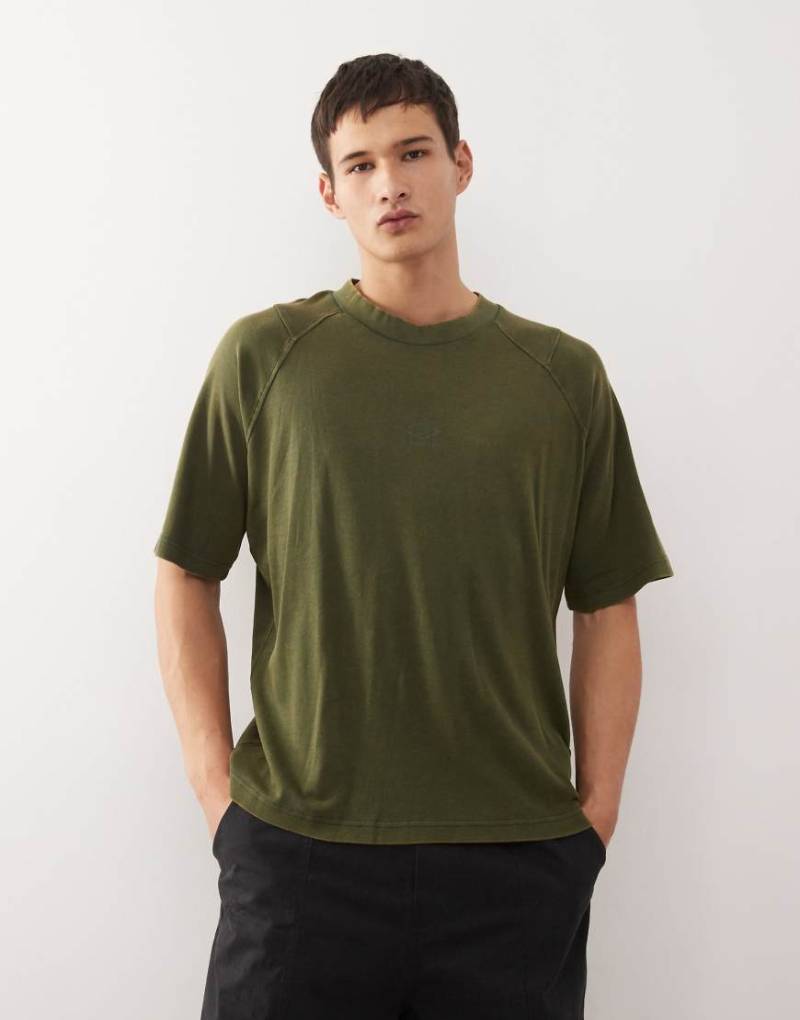 Umbro - Hochgeschlossenes, kastiges T-Shirt in verwaschenem Grün Umbro - Hochgeschlossenes, kastiges T-Shirt in verwaschenem Grün von Umbro