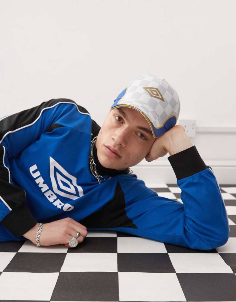 Umbro - Kappe in Weiß und Gold mit Logo und Bahnen-Design von Umbro