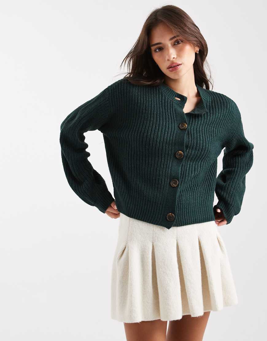 Vero Moda - Breit gerippte Strickjacke in Piniengrün mit Rundhalsausschnitt Vero Moda - Breit gerippte Strickjacke in Piniengrün mit Rundhalsausschnitt von Vero Moda