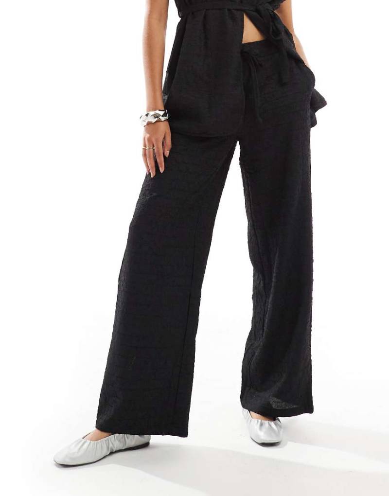 Vero Moda - Strukturierte Hose in Schwarz mit lockerem Schnitt, Kombiteil Vero Moda - Strukturierte Hose in Schwarz mit lockerem Schnitt, Kombiteil von Vero Moda
