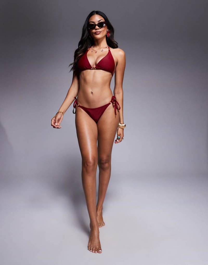 Wolf & Whistle - Seitlich gebundene Bikinihose in Rot mit goldfarbenem Metallbesatz-Bunt von Wolf & Whistle